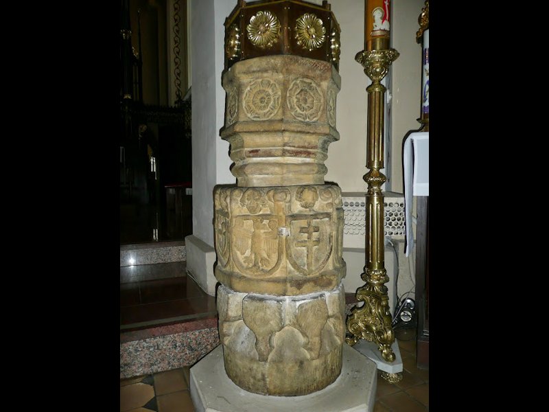 XVI-wieczna ośmioboczna chrzcielnica ozdobiona renesansowym ornamentem i herbami