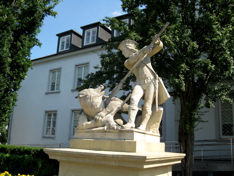 Rzeźba plenerowa w przypałacowym parku przedstawiająca scenę z polowania na dzika