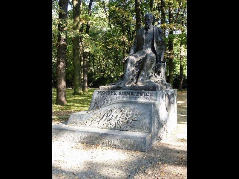 Monument przedstawiający pisarza w pozycji siedzącej, upuszczającego kartki rękopisu. Uwagę zwraca wiarygodne oddanie rysów twarzy SIENKIEWICZA