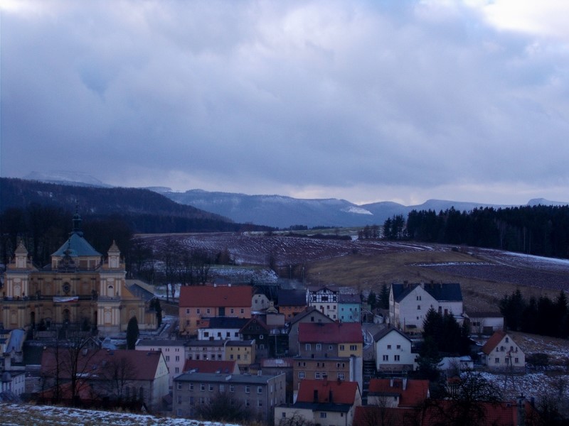 Z Góry Kalwarii roztacza się widok na Wambierzyce, a w oddali na polskie (po lewej) i czeskie (po prawej) Góry Stołowe